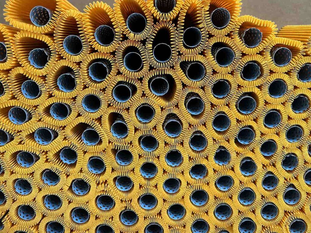 Pleated filter media packs assembled with perforated inner mesh tubes before end cap bonding