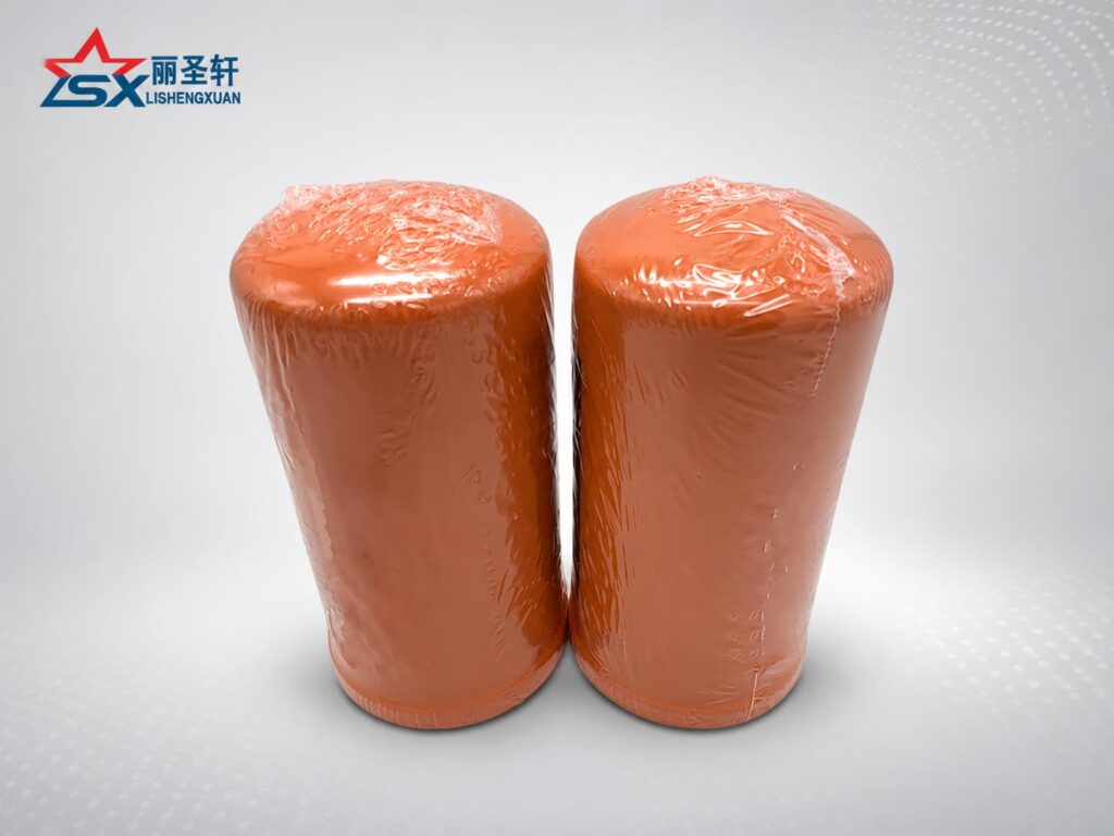 Orange spin-on oil filter elements wrapped in plastic for industrial equipment replacement